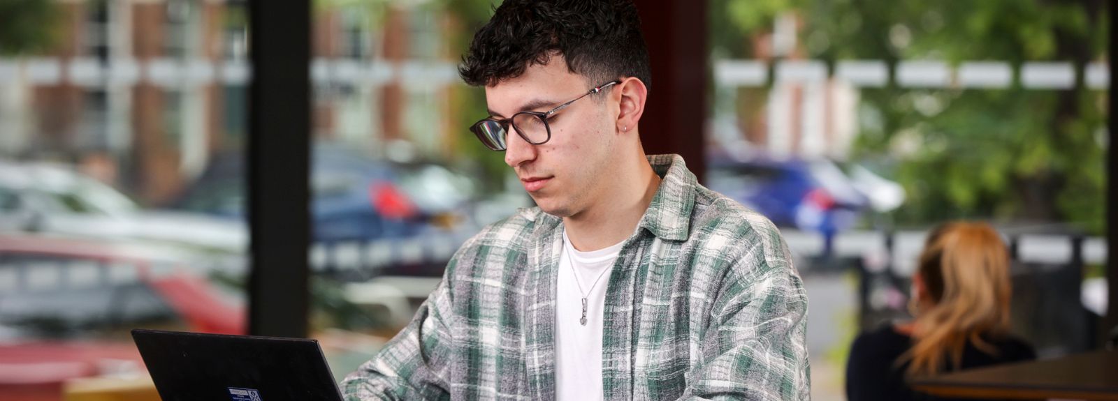 male student sitting on laptop
